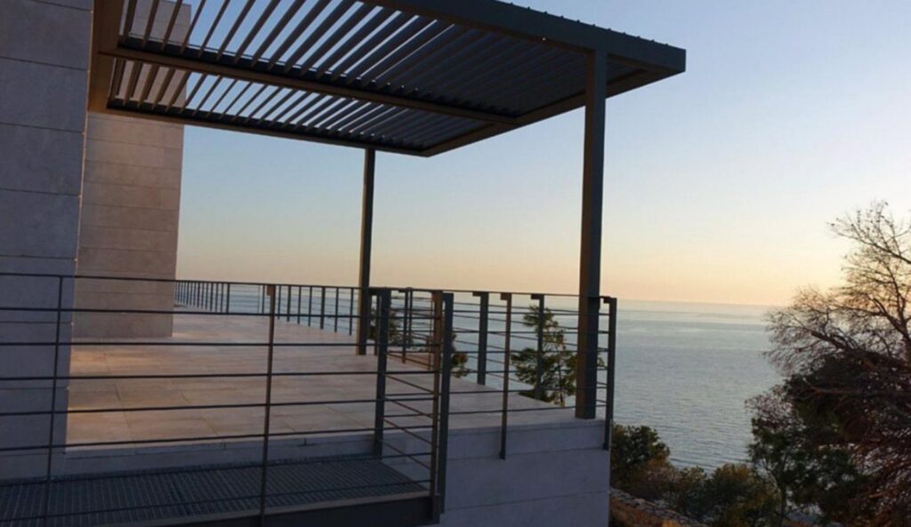 Modelo Smart+ louvred pergola on a coastal rooftop terrace